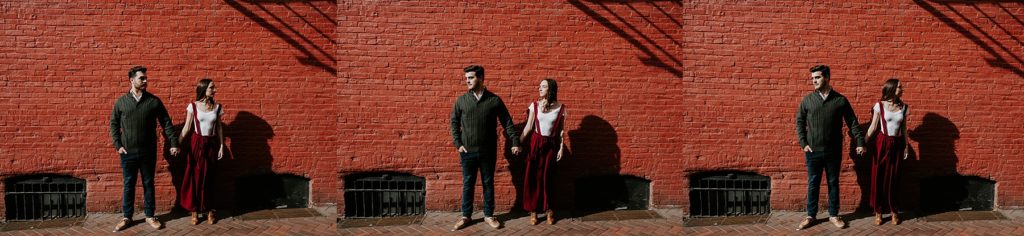 Couple standing beside one another with eyes shut outside of Lancaster Central Market in Downtown Lancaster, PA