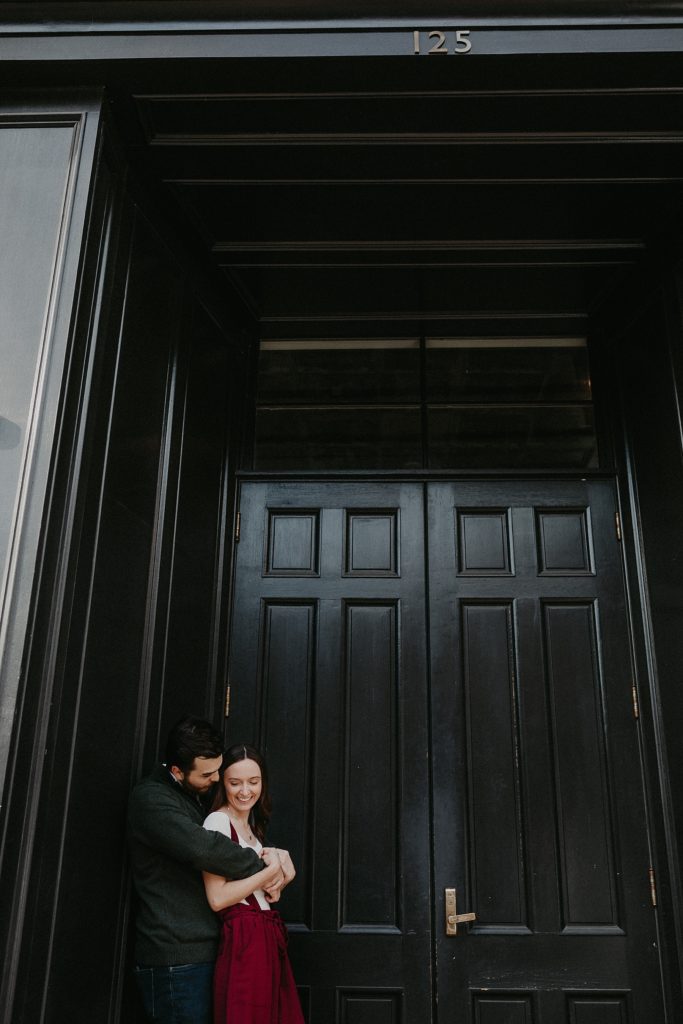 Engaged couple wrapped up in a sweet embrace during engagement photos in Downtown Lancaster, PA