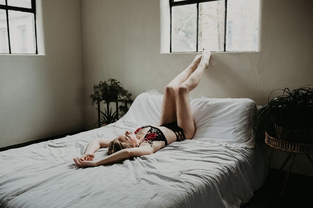 Sexily clad back and red lingerie worn by female during studio boudoir shoot in Downtown York, PA