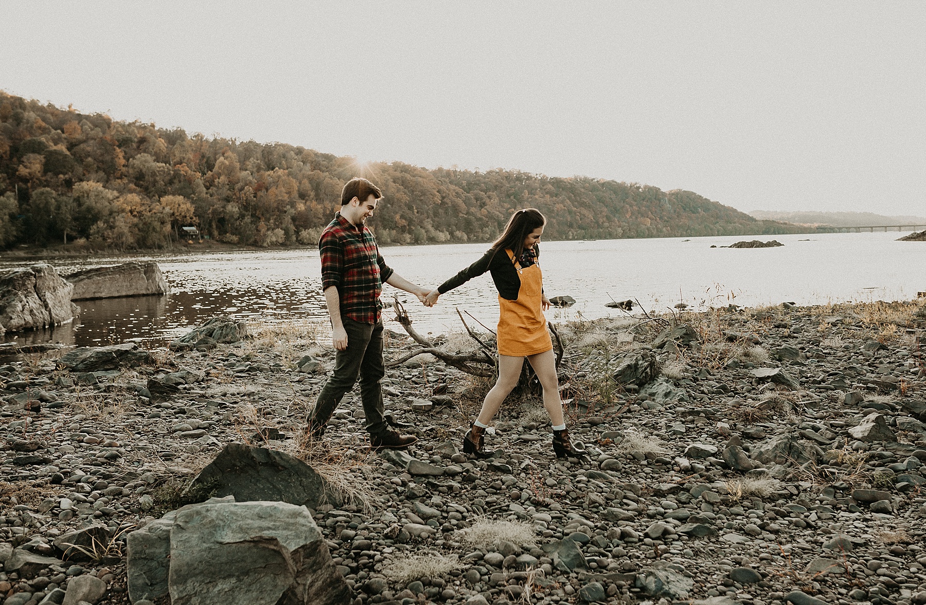 Engaged couple standing hand in hand as they walk along the Susquehanna River
