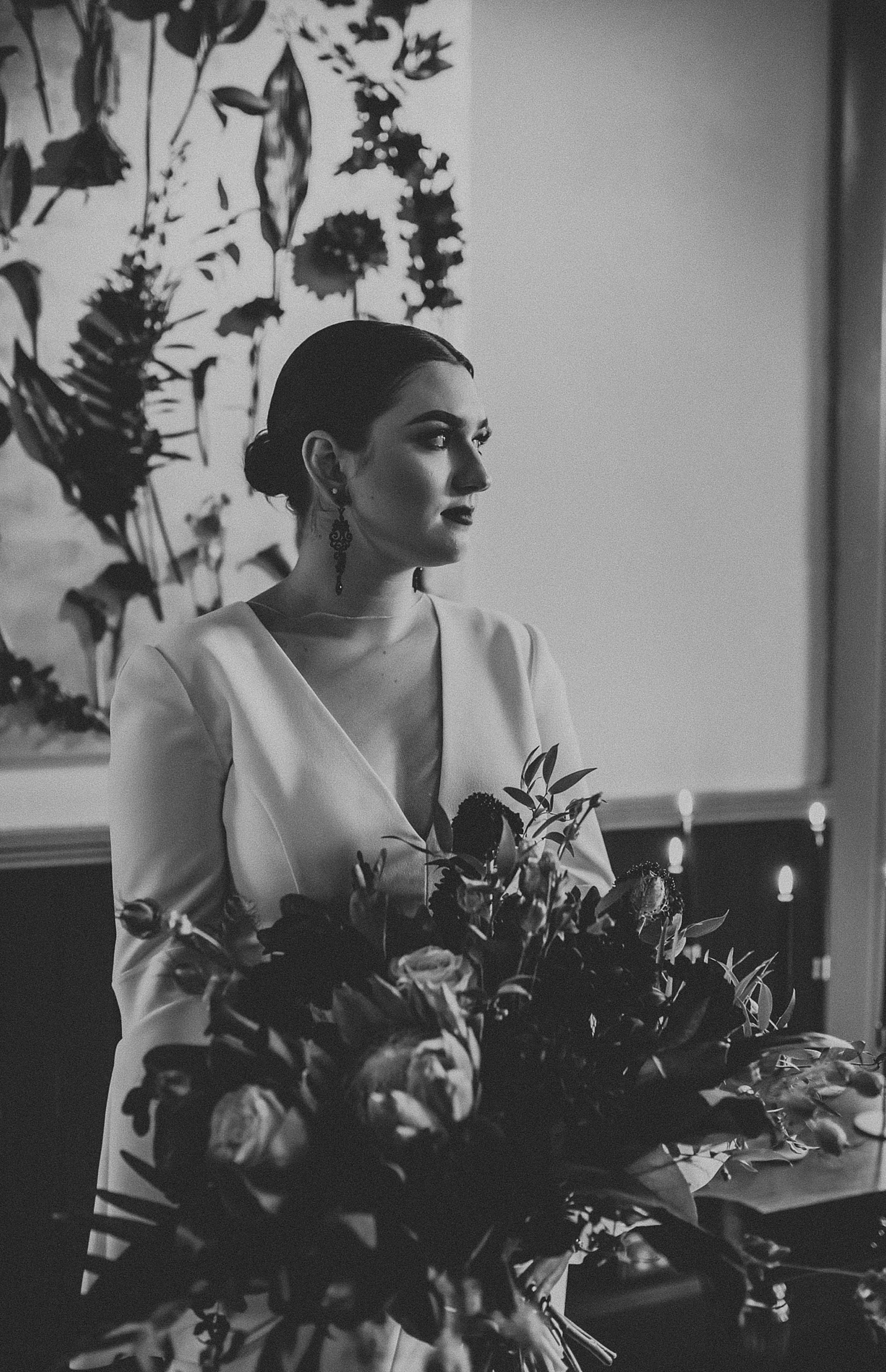 Dramatic dark and moody Bridal Portraits with oversized boho wedding bouquet in high slit wedding dress