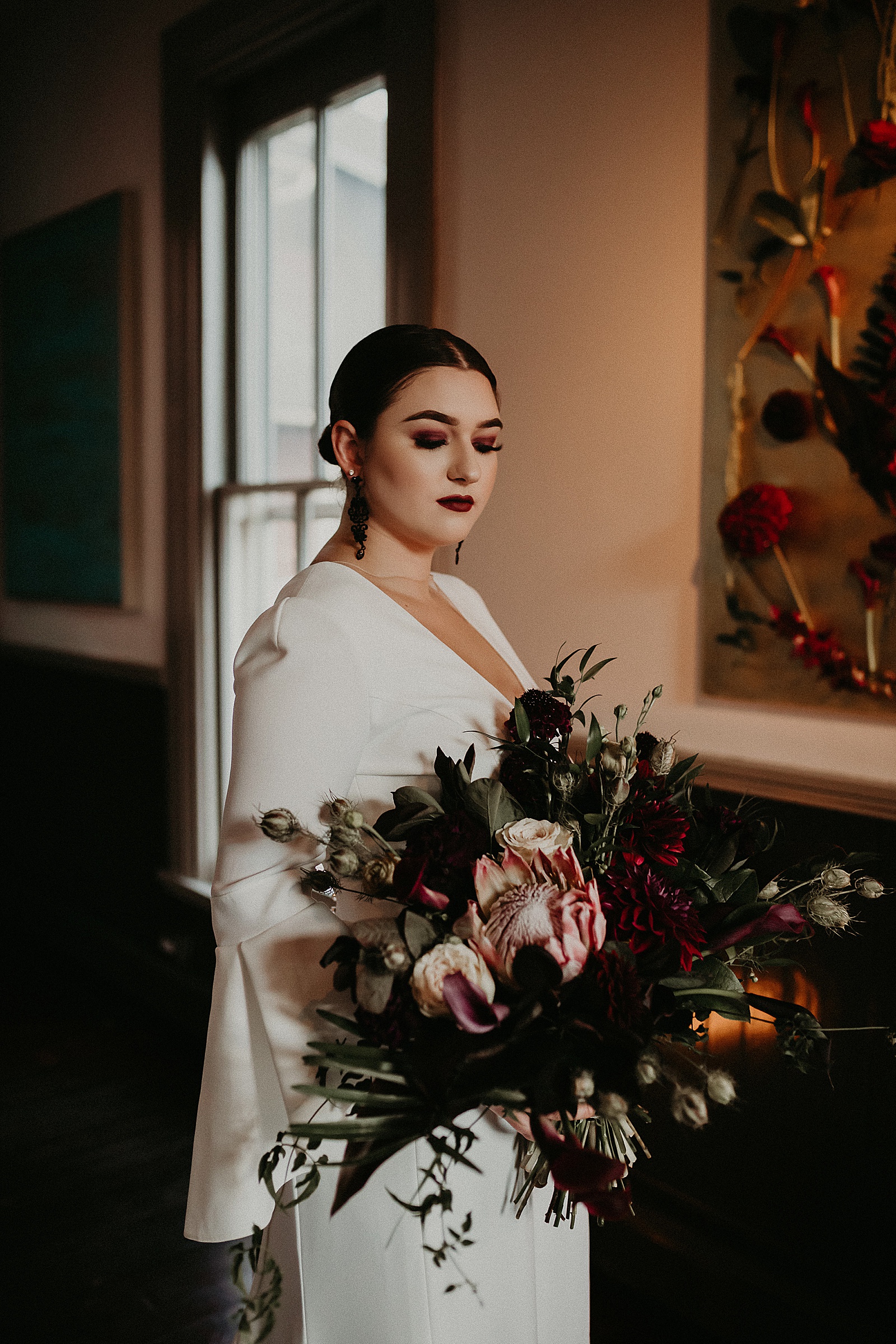 Dramatic dark and moody Bridal Portraits with oversized boho wedding bouquet in high slit wedding dress