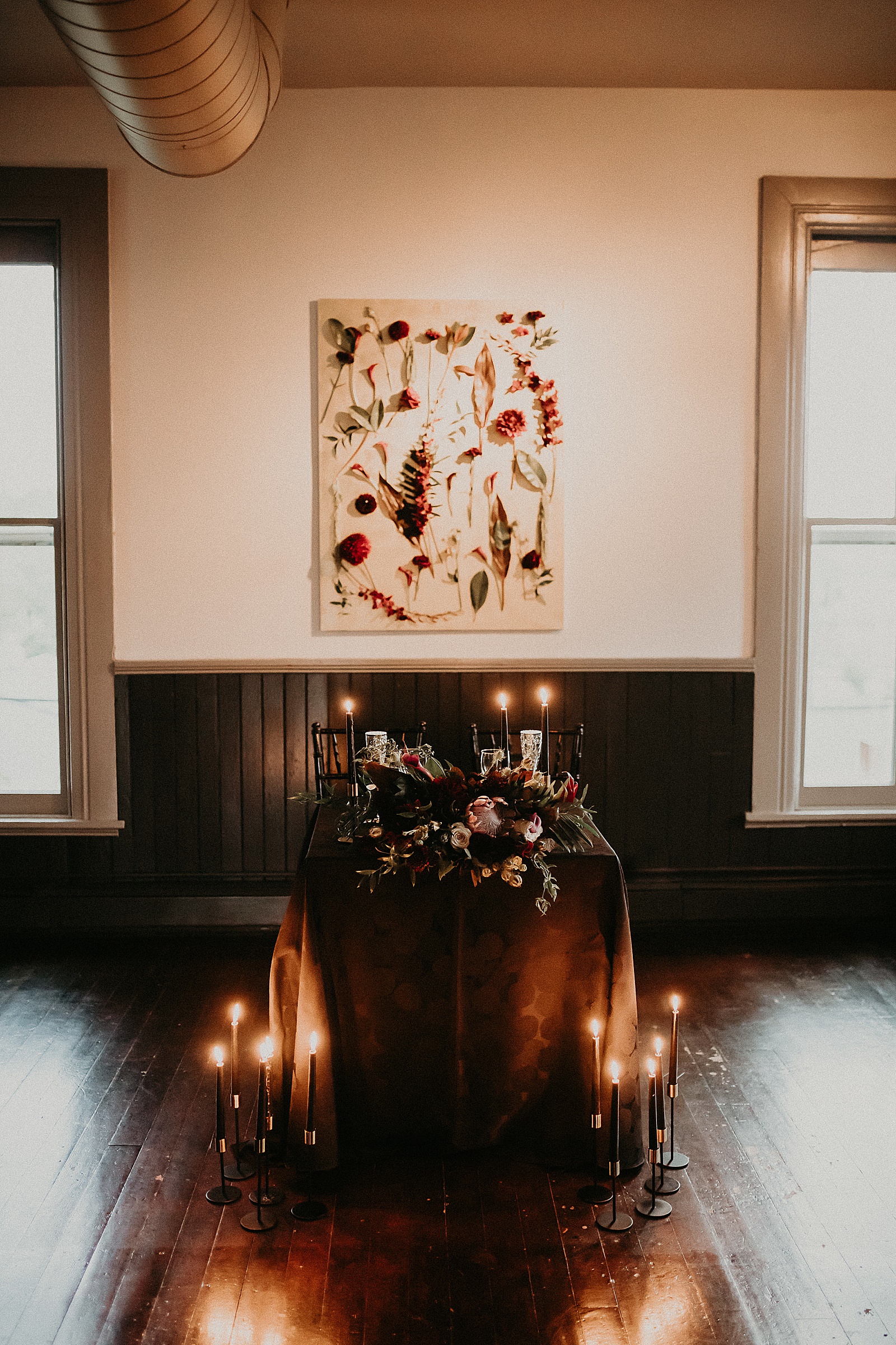 Sweetheart table with candles and dramatic bouquet placed in center