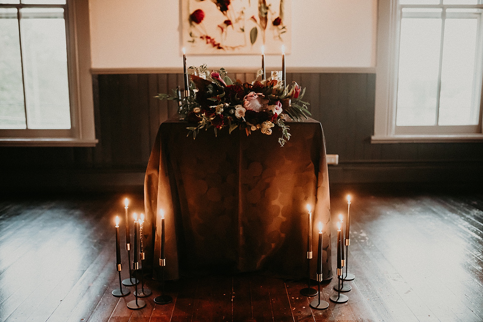 Sweetheart table with candles and dramatic bouquet placed in center