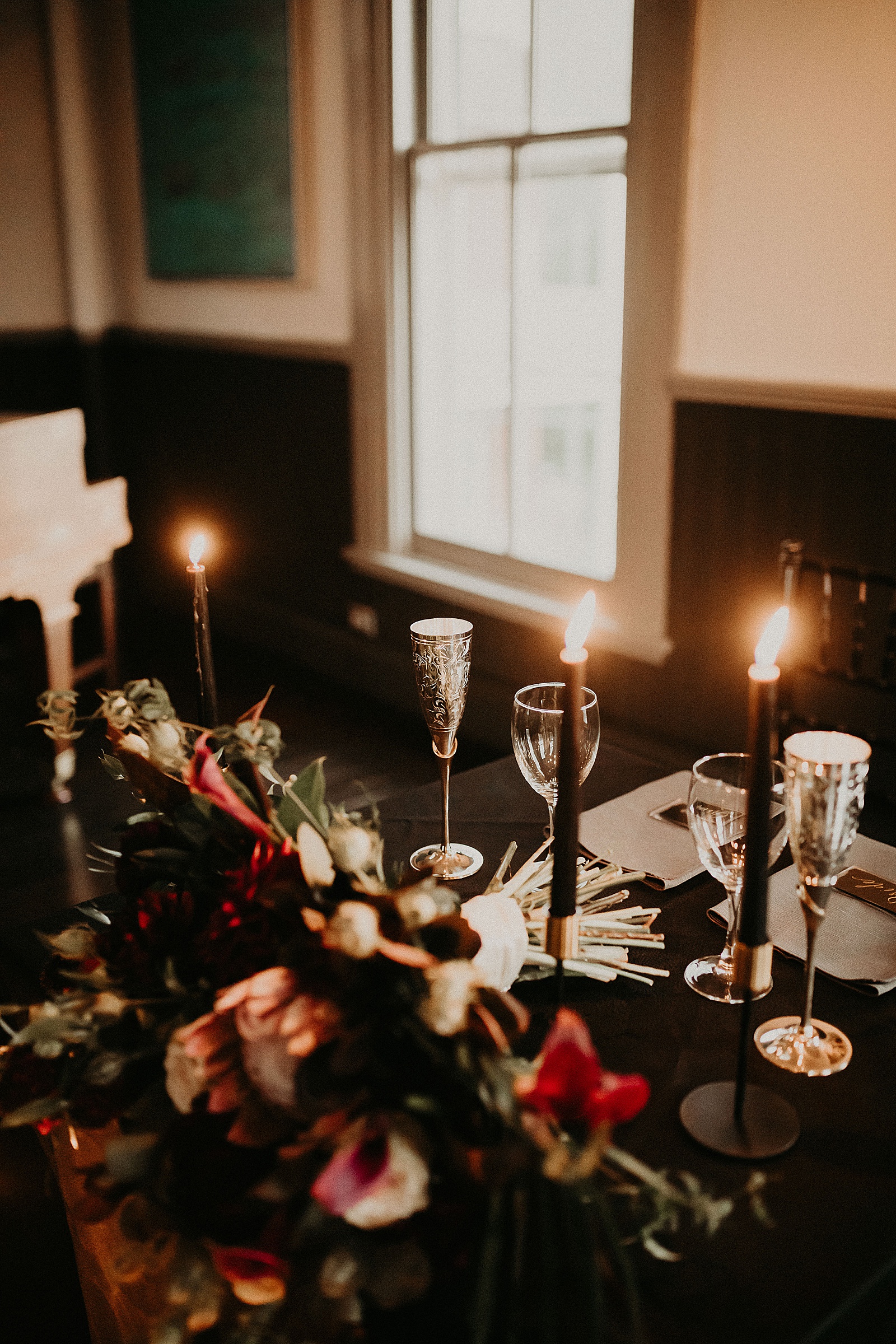 Sweetheart table with candles and dramatic bouquet placed in center
