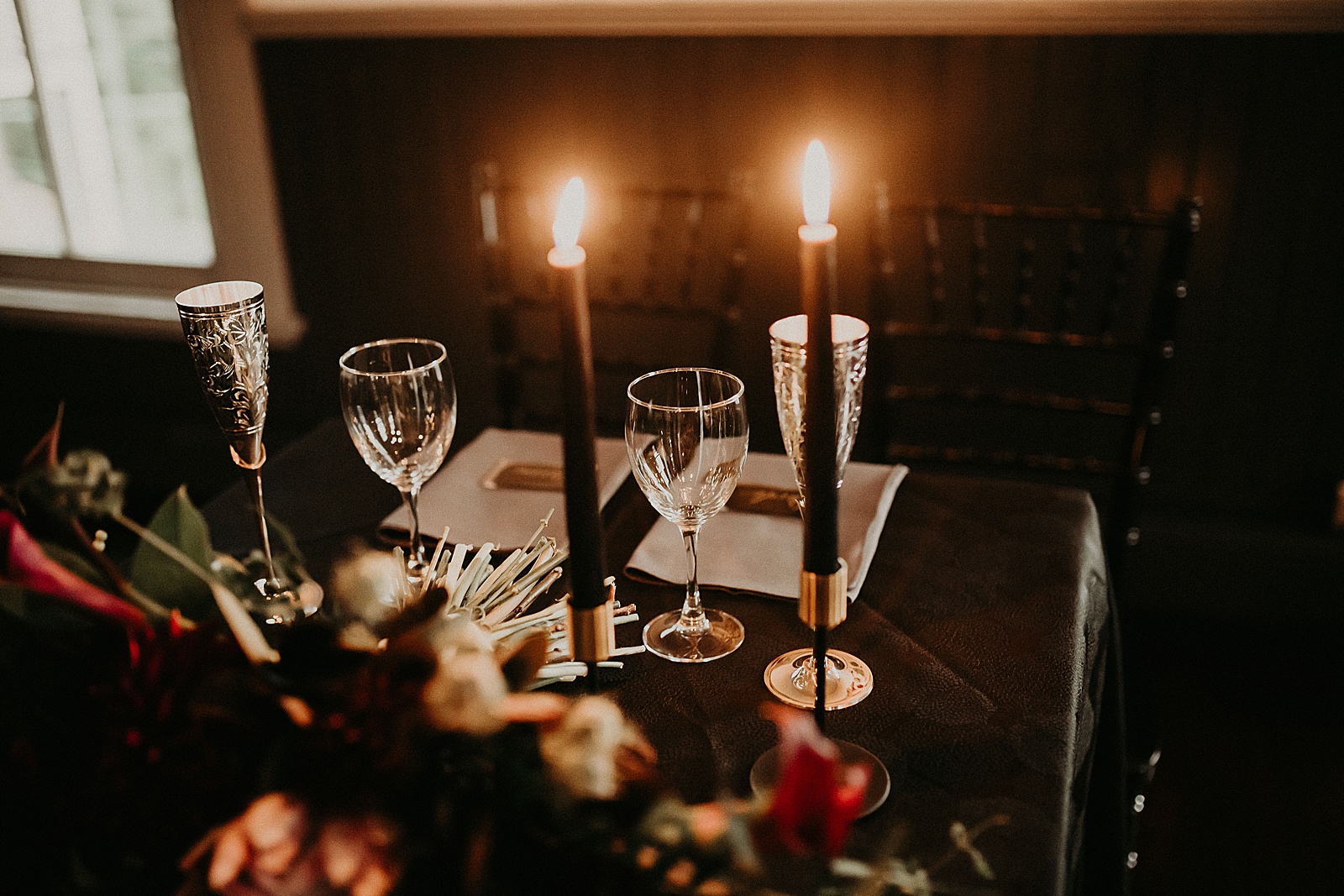 Sweetheart table with candles and dramatic bouquet placed in center