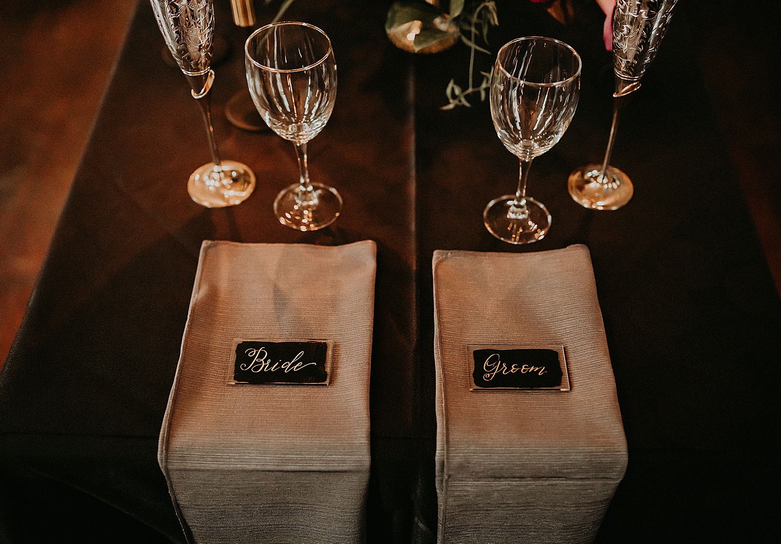 Sweetheart table with candles and dramatic bouquet placed in center