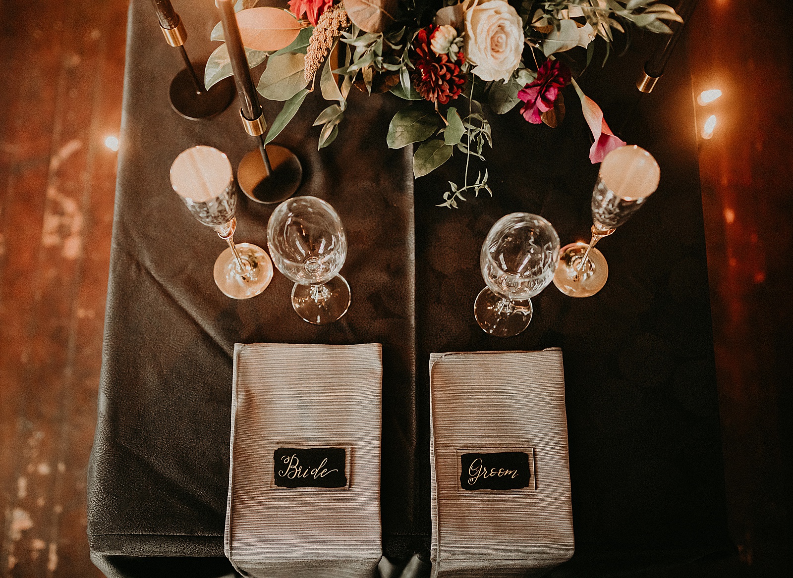 Sweetheart table with candles and dramatic bouquet placed in center