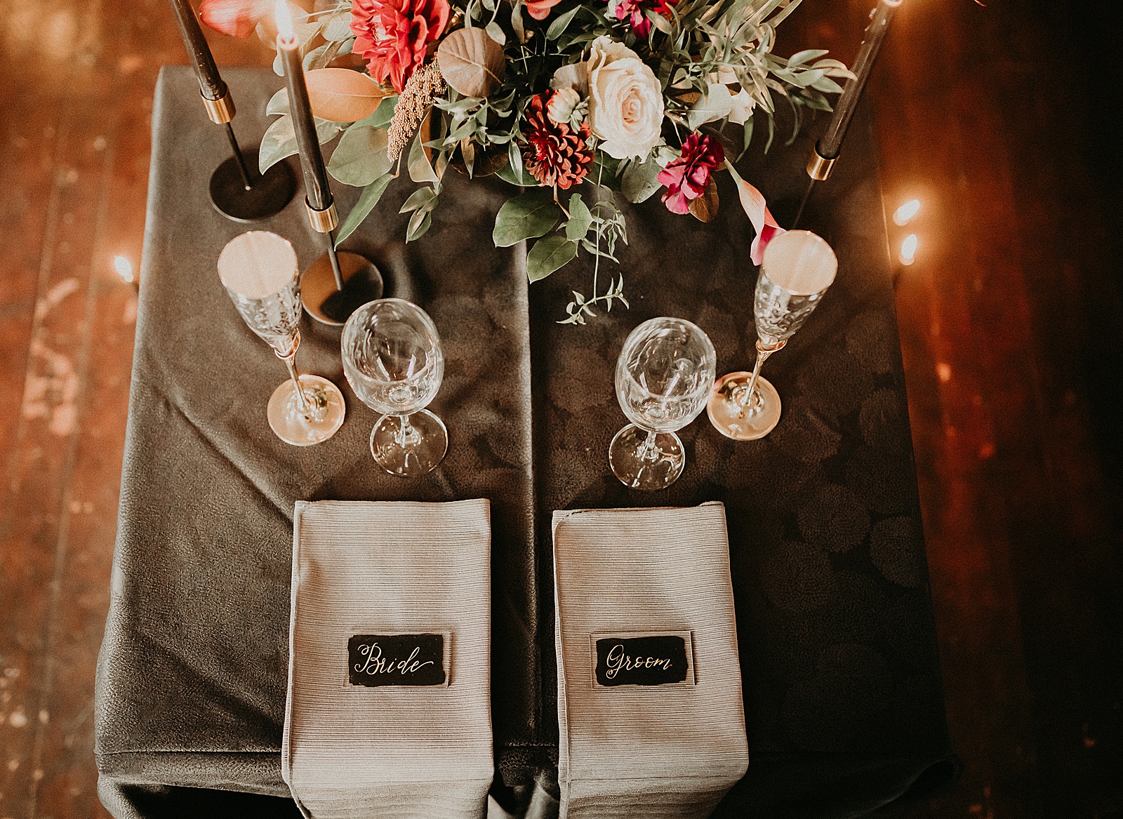 Sweetheart table with candles and dramatic bouquet placed in center