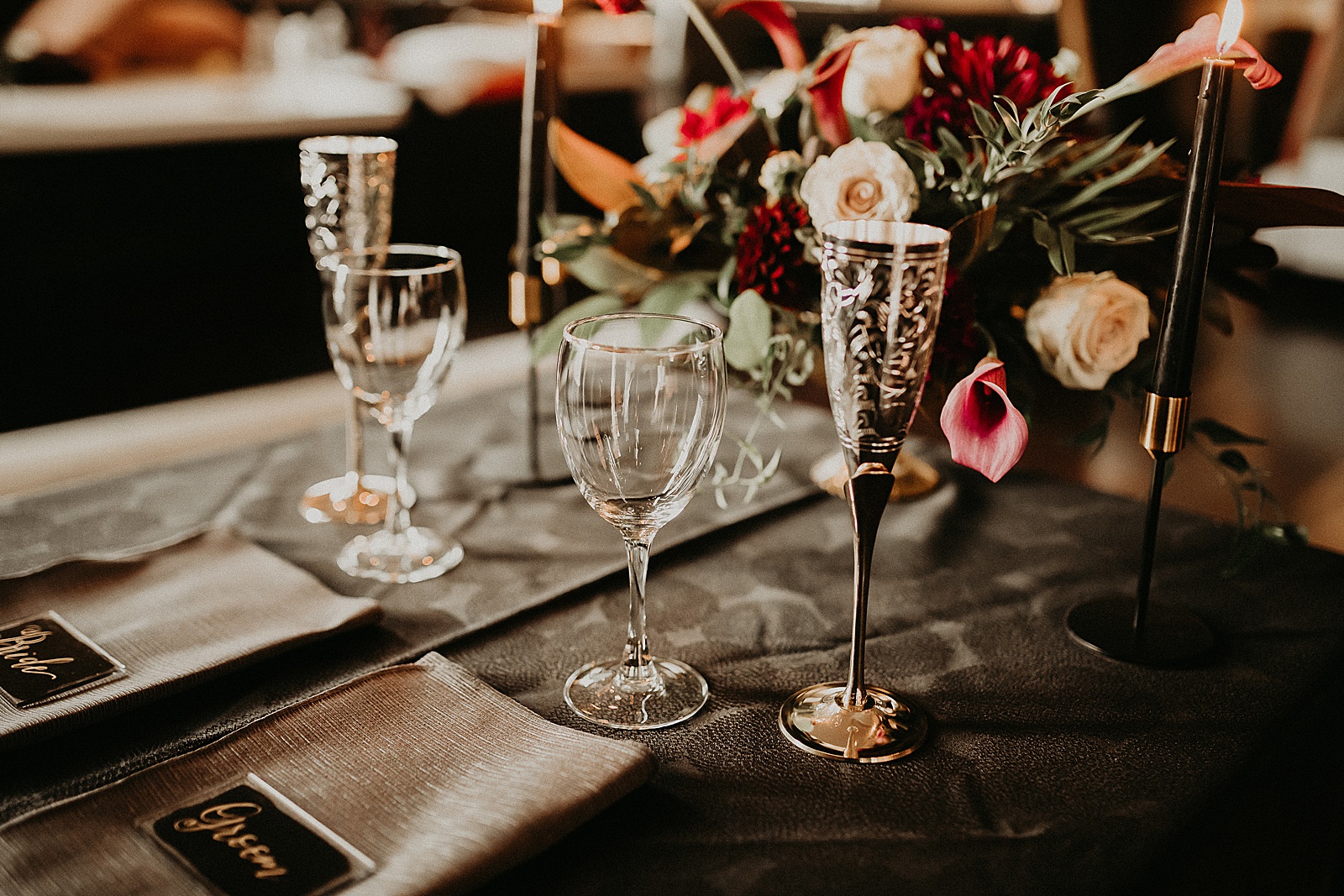 Sweetheart table with candles and dramatic bouquet placed in center