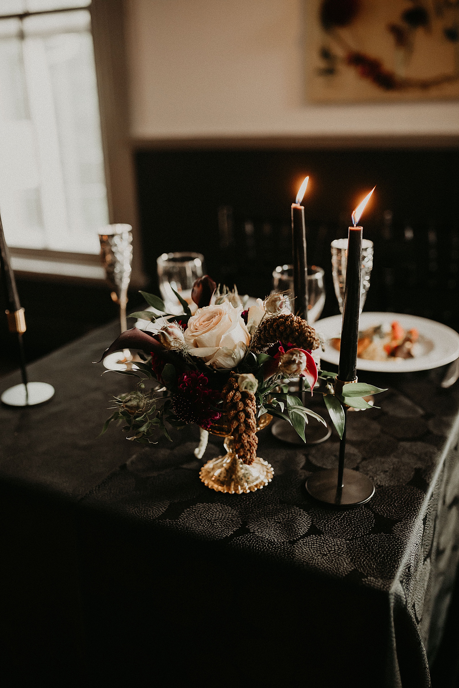 Sweetheart table with candles and dramatic bouquet placed in center