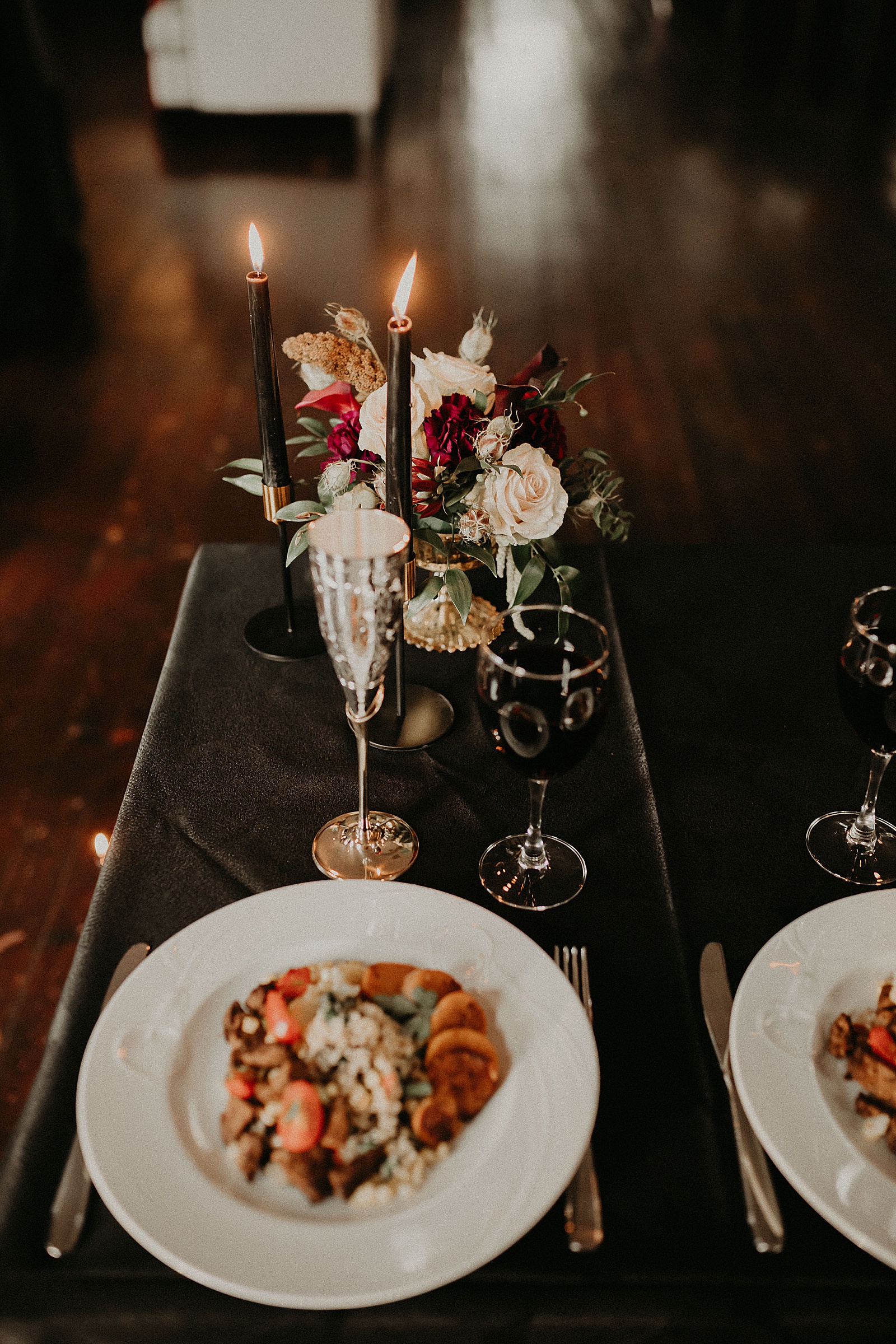 Sweetheart table with candles and dramatic bouquet placed in center