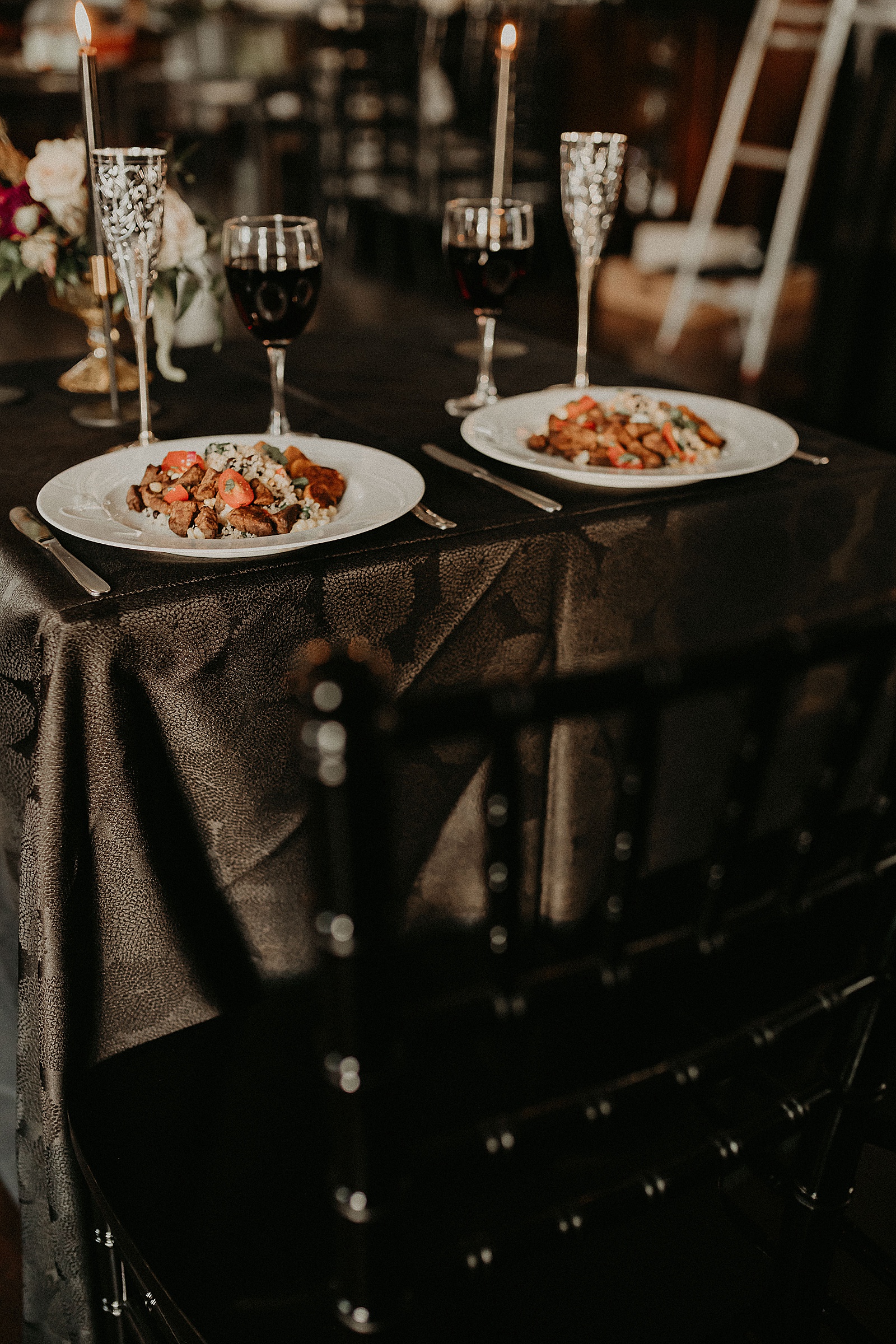 Sweetheart table with candles and dramatic bouquet placed in center