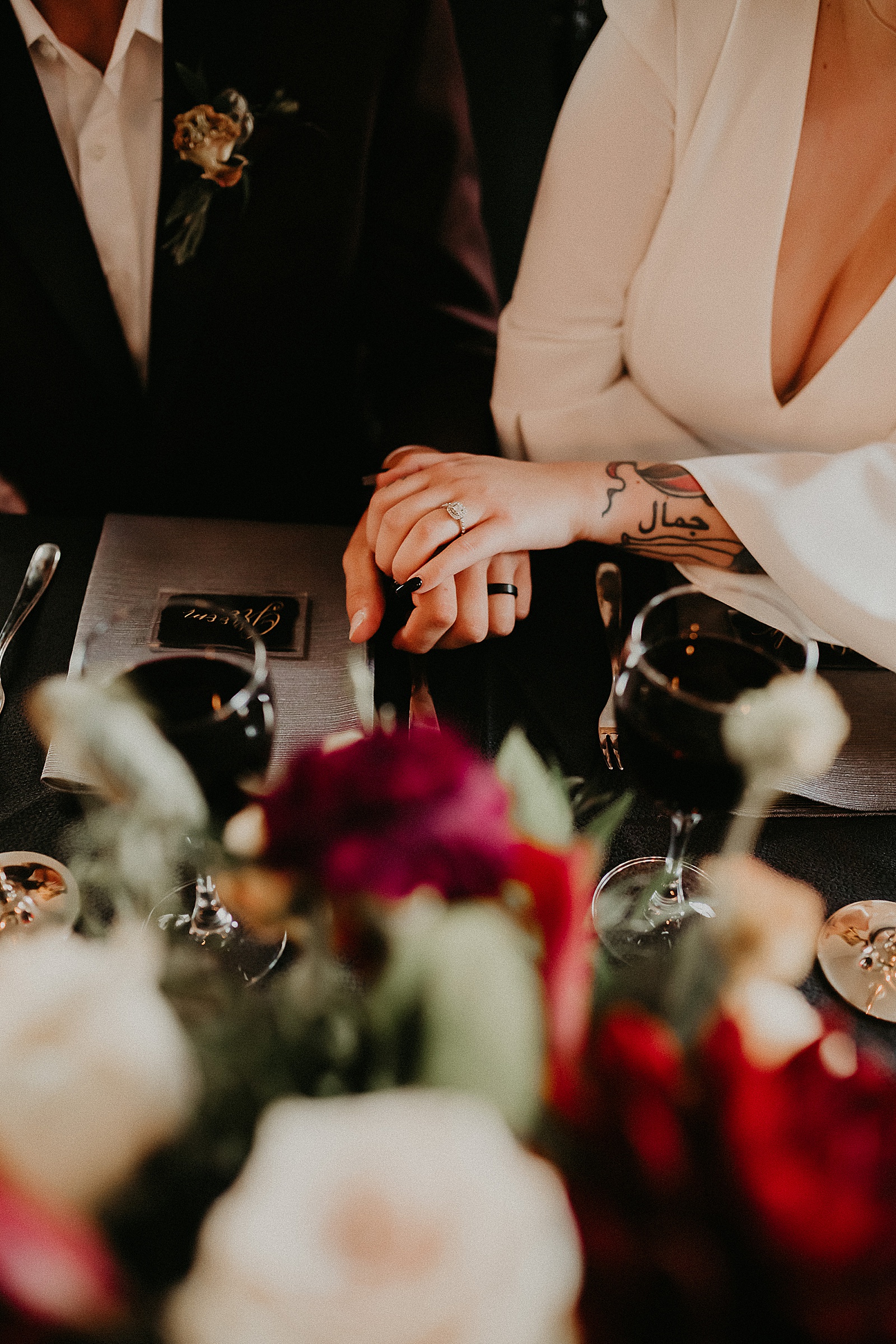 Bride and groom sitting at sweetheart table laughing over their reception dinner