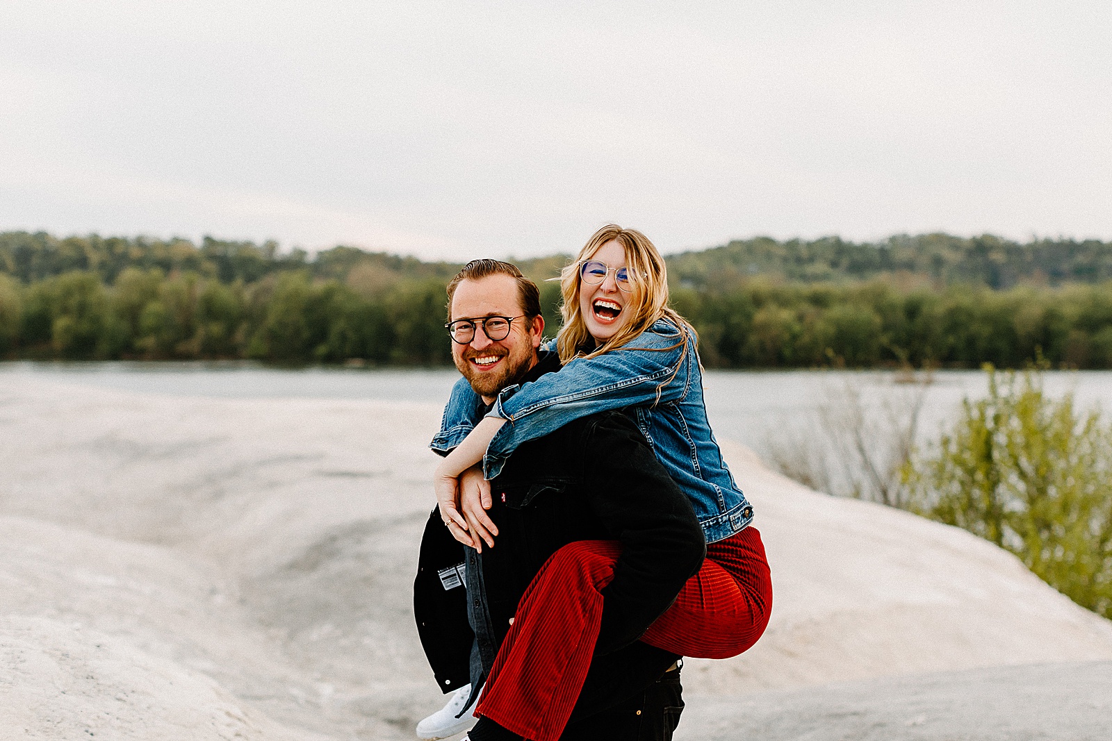 Candid piggyback rides during couples adventure session at White Cliffs of Conoy